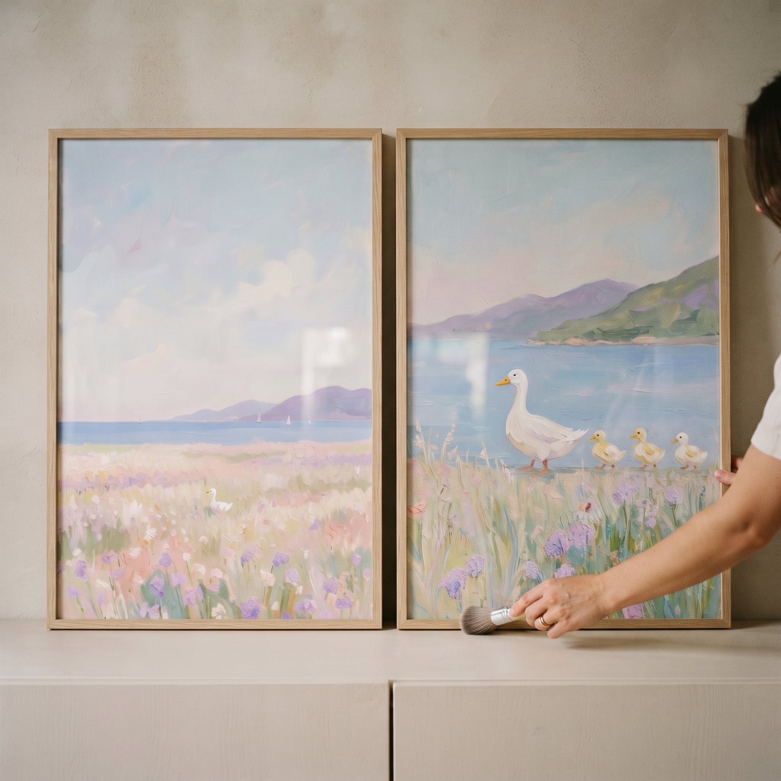 Scenic seaside white duck wall art set of 2 in light wood frames featuring ducks by a coast with flowers and hills.