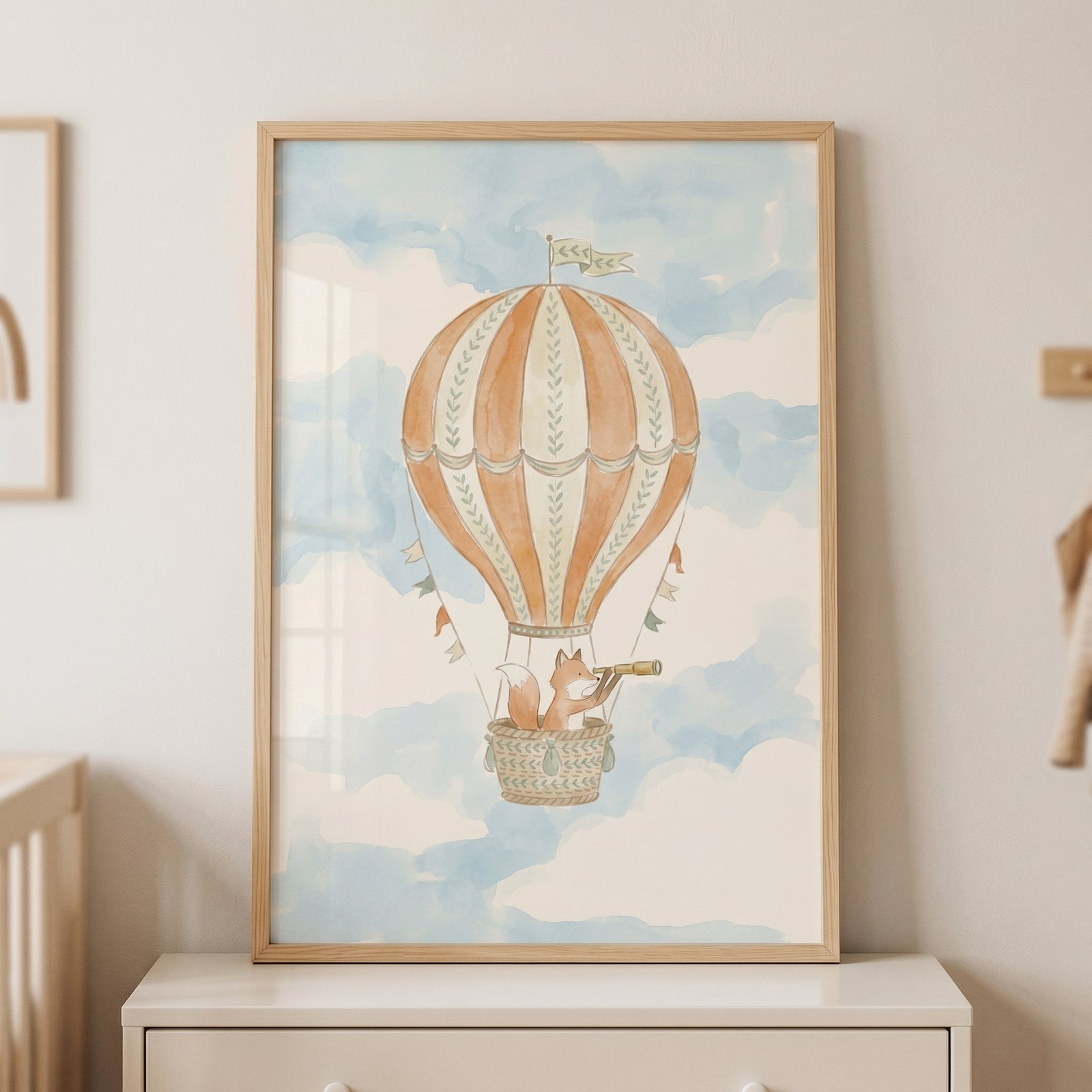 Scouting telescope watercolor fox wall art shows a fox in a striped hot air balloon basket floating among blue clouds.