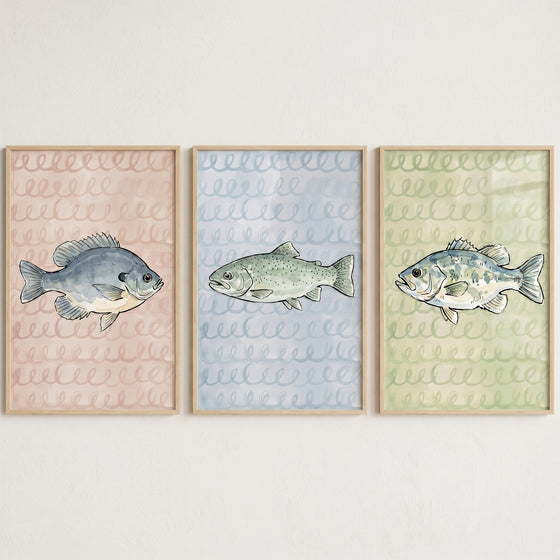 Scribble background watercolor fish wall art set of 3 with a bluegill, trout, and bass in light wood frames.