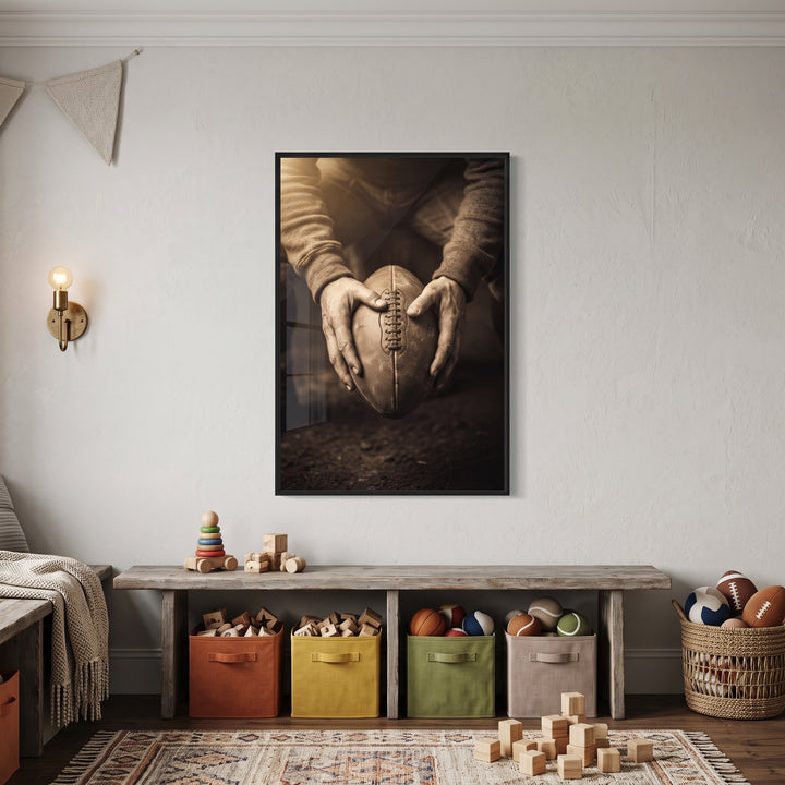 Sepia hands holding football sports wall art over a wooden bench with colorful storage bins and a basket of sports balls.