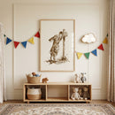 Framed sepia watercolor mail bunny wall art hangs in a nursery above a wooden shelf with toys and colorful bunting.