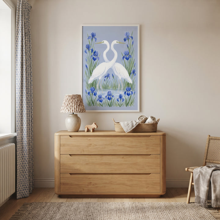 Serene aquatic floral egret bird wall art hangs above a light wood dresser in a neutral room with a lamp and woven rug.