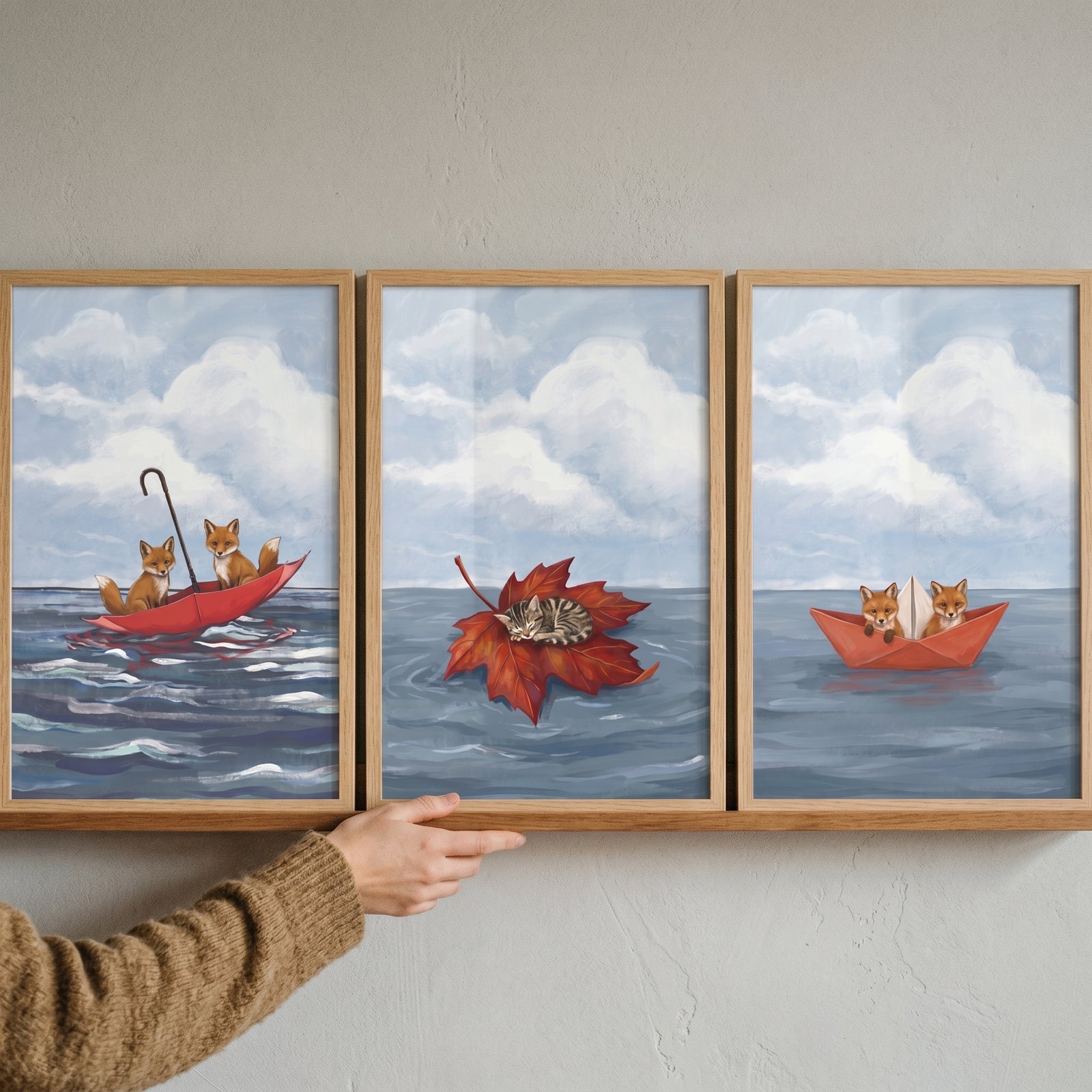 Serene blue ocean animals wall art set of 3 with foxes in an umbrella and paper boat, and a cat resting on a leaf.