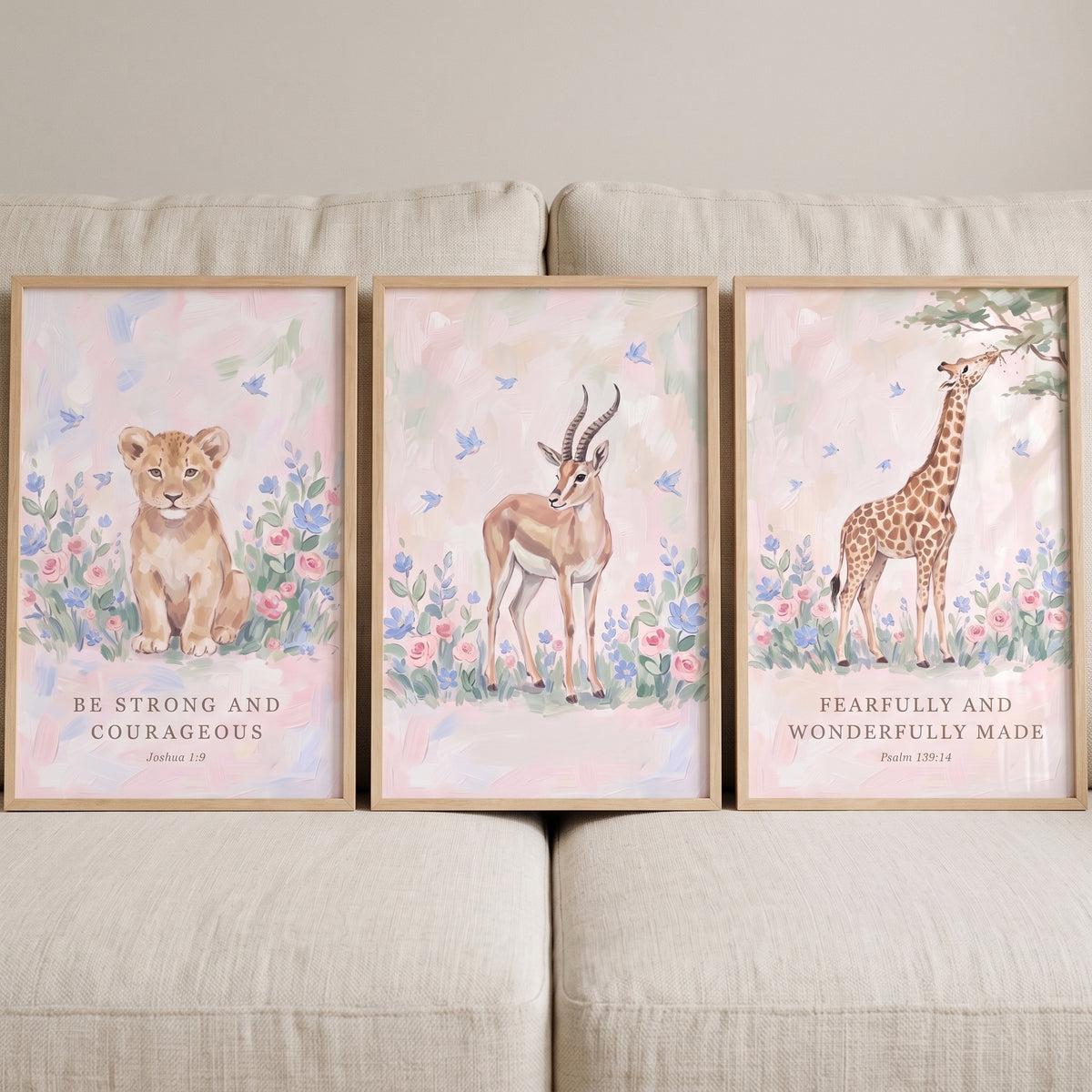 Serene botanical savanna animals artwork set of 3 featuring a lion, gazelle, and giraffe with Bible verses on a beige sofa.