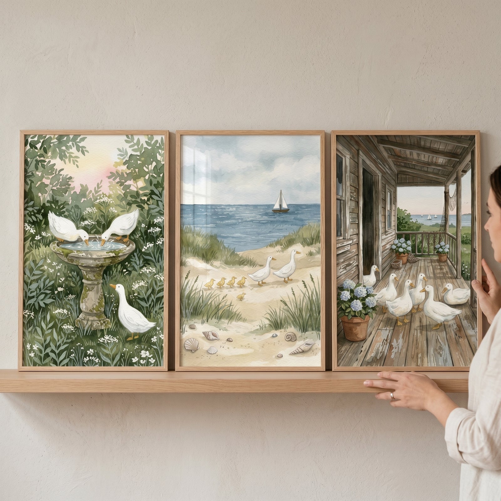 Serene nature white duck wall art set of 3 shows ducks in a garden, on a beach, and on a porch as a hand touches a frame.