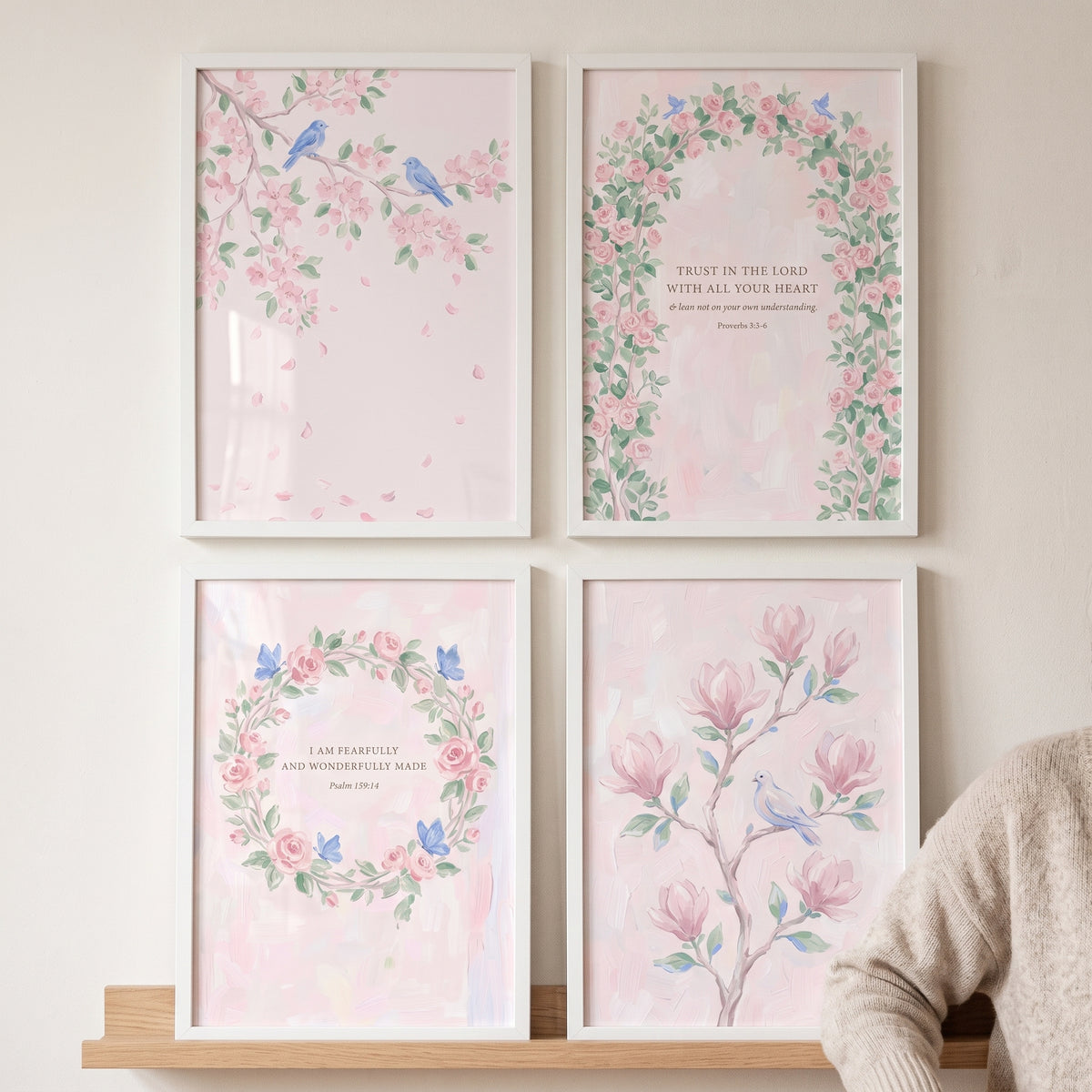 Shabby chic blush floral wall art set of 4 featuring flowers, birds, and religious quotes in white frames on a wooden shelf.
