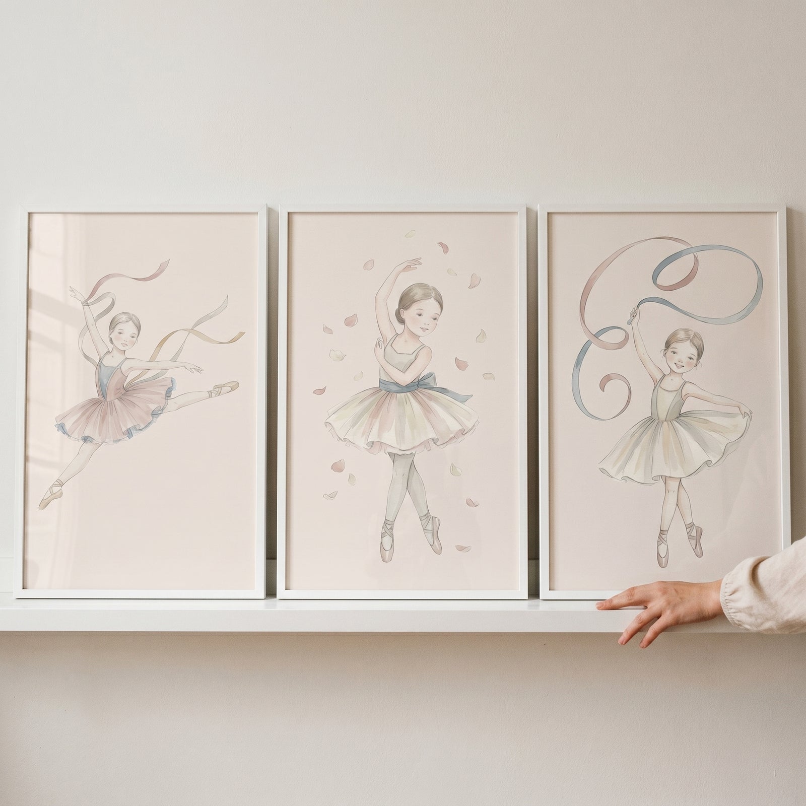 Shabby chic neutral ballerina wall art set of 3 featuring framed illustrations of young dancers in tutus on a white shelf.