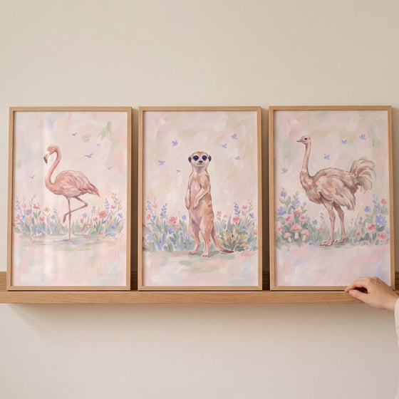 Shabby chic savanna animals wall art set of 3 featuring a flamingo, meerkat, and ostrich in frames on a wooden shelf.