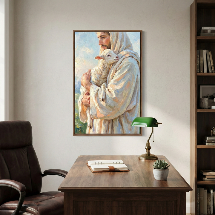 A cozy office features a wooden desk with a green desk lamp, a notebook, and a small potted plant. On the wall hangs a painting of a person in a robe gently holding a lamb, creating a serene atmosphere.