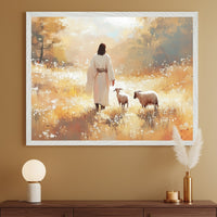 Modern room with a dark wood console table. A large framed painterly print depicts a robed figure walking with two sheep in a golden, flowery field, hung above the table. A lamp, vase with pampas grass, and candle are on the table.