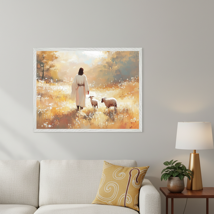 Living room with a light gray sofa, yellow pillow, and a wooden end table with a golden lamp. A large framed impressionistic painting, showing Jesus in a white robe walking with two sheep in a golden, sunlit field with wildflowers, hangs above the sofa.