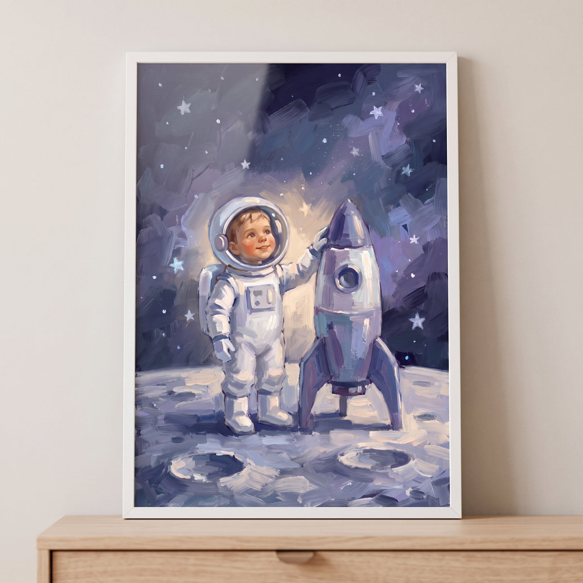 Silver rocket baby astronaut wall art shows a child in a space suit standing on the moon next to a small rocket.