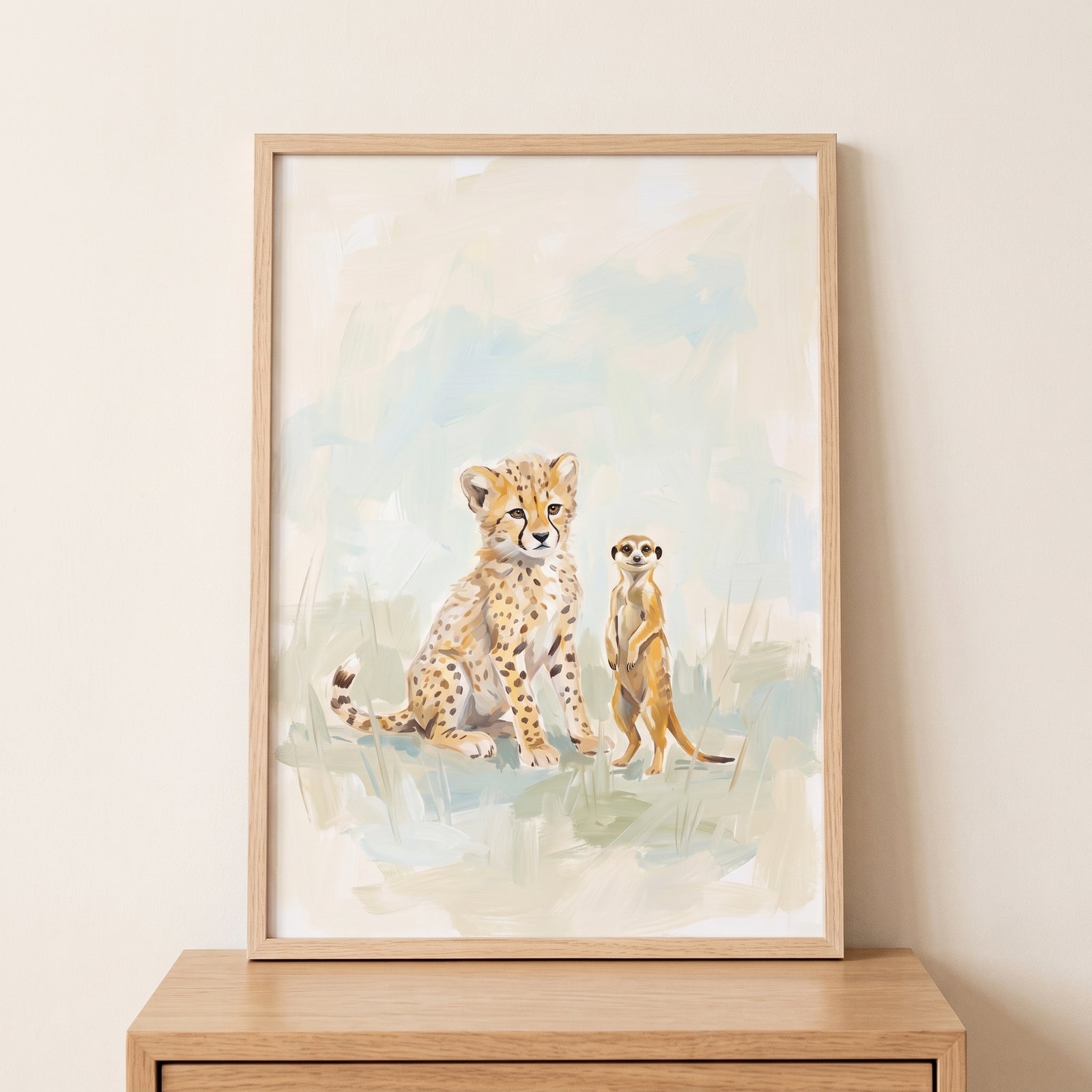 Framed sitting spotted cheetah meerkat animals wall art resting on a wooden surface against a neutral wall.
