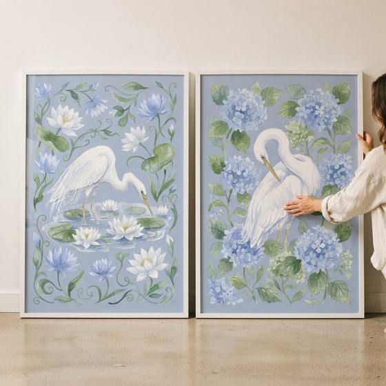Sky blue botanical egret bird wall art set of 2 with white egrets, water lilies, and blue hydrangeas.