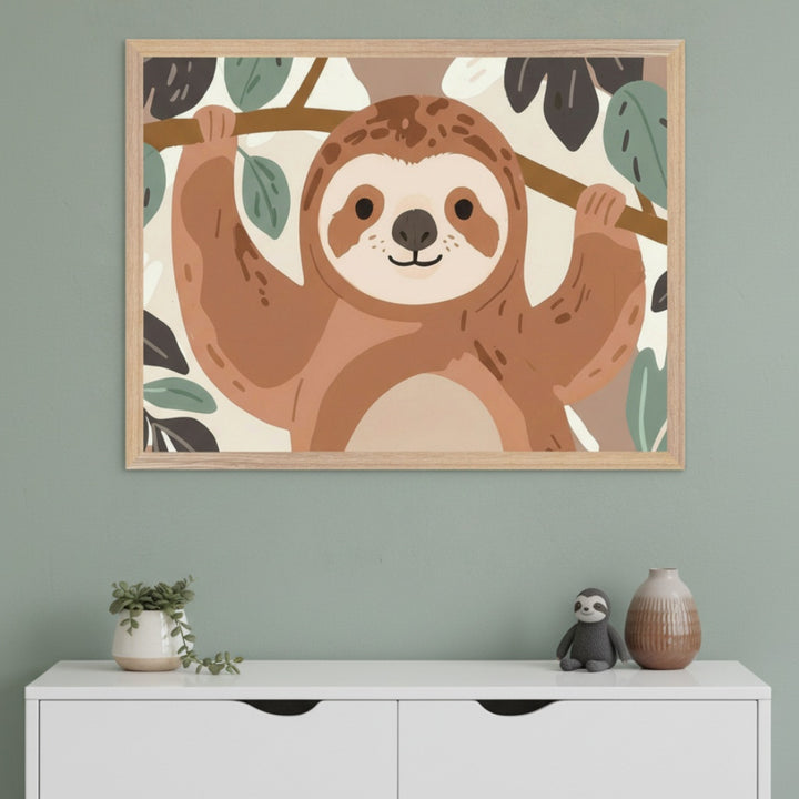 Modern nursery with a white dresser against a green wall. A framed illustration of a smiling brown sloth hanging from a branch in a flat graphic style is centered above the dresser. A succulent, sloth plush, and vase are on the dresser.