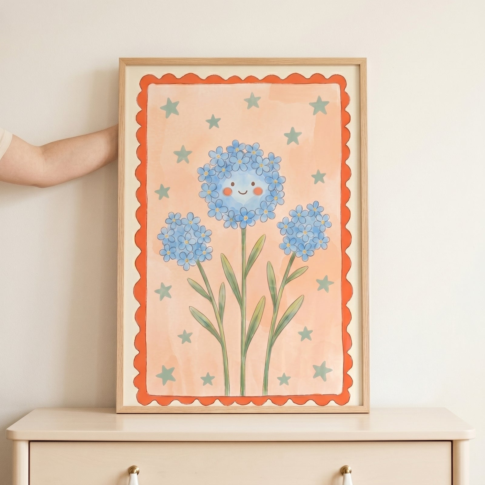 Smiley face blue flower wall art with green stars and a scalloped orange border, framed in wood above a dresser.