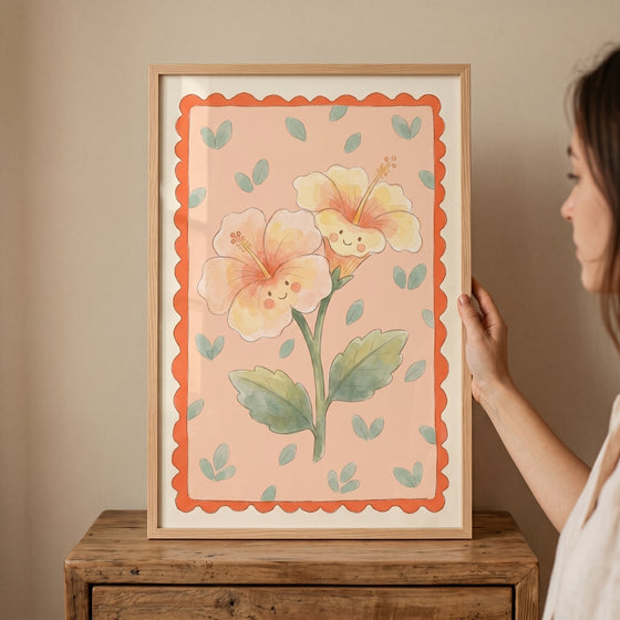 Smiley face yellow hibiscus flower wall art on a pink backdrop with a scalloped orange border and light wood frame.
