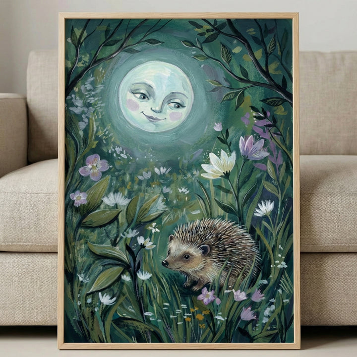 A vertical, framed artwork featuring a whimsical night scene. A large, glowing moon with a gentle, smiling human face occupies the upper center. Below, a small, detailed hedgehog walks through a lush meadow of tall grass, white daisies, and purple flowers. Dark, leafy branches frame the top edges. The piece has visible, textured brushwork in deep greens, teals, and soft highlights. The light wood frame rests against a neutral-toned fabric sofa.