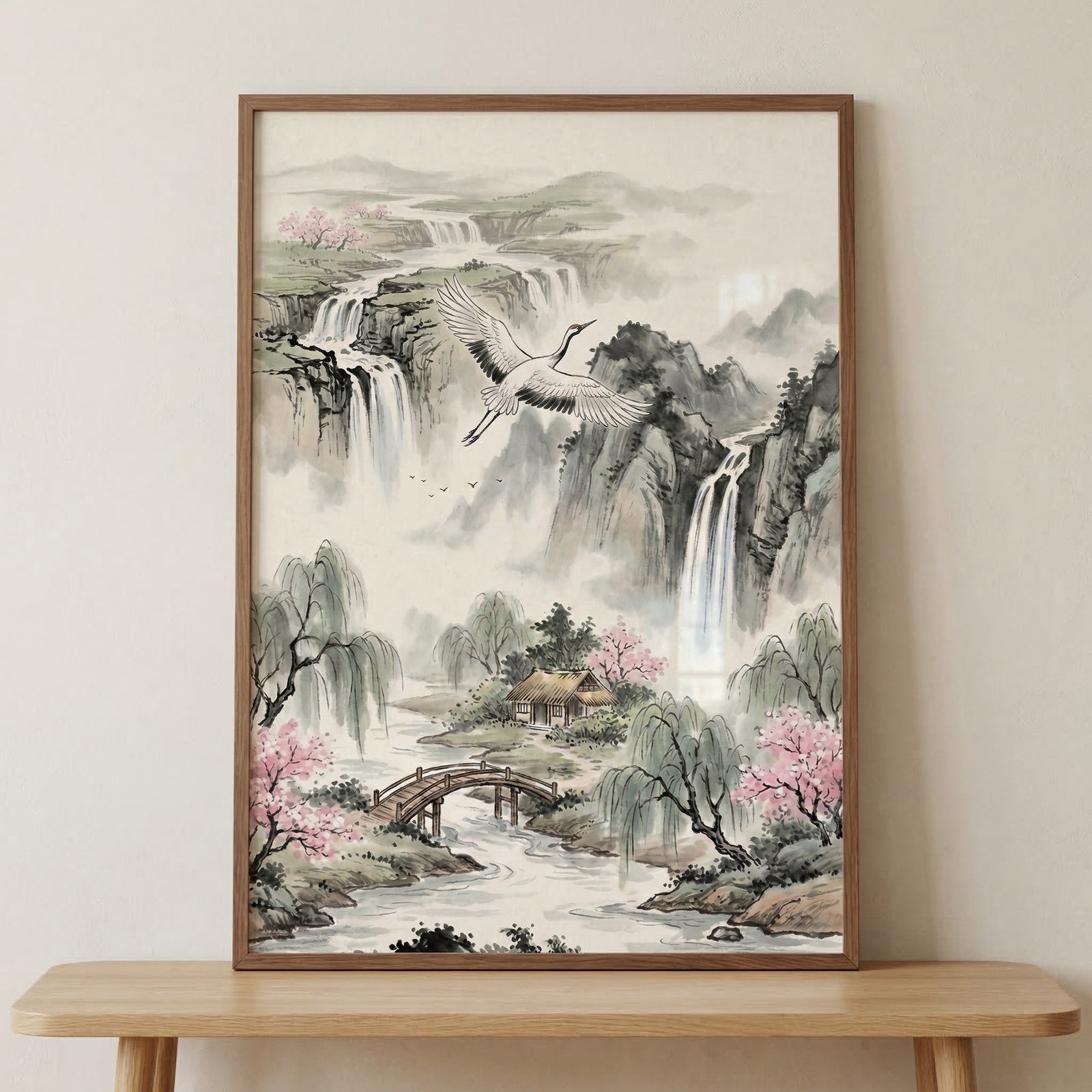 This vertical-oriented landscape artwork in an ink and wash style depicts a serene and traditional East Asian scene. In the upper half, multiple waterfalls cascade down steep, rocky cliffs, disappearing into a soft mist that blankets the base of the mountains. A large crane with white and black plumage is captured in mid-flight across the center of the composition, its wings fully extended. 

