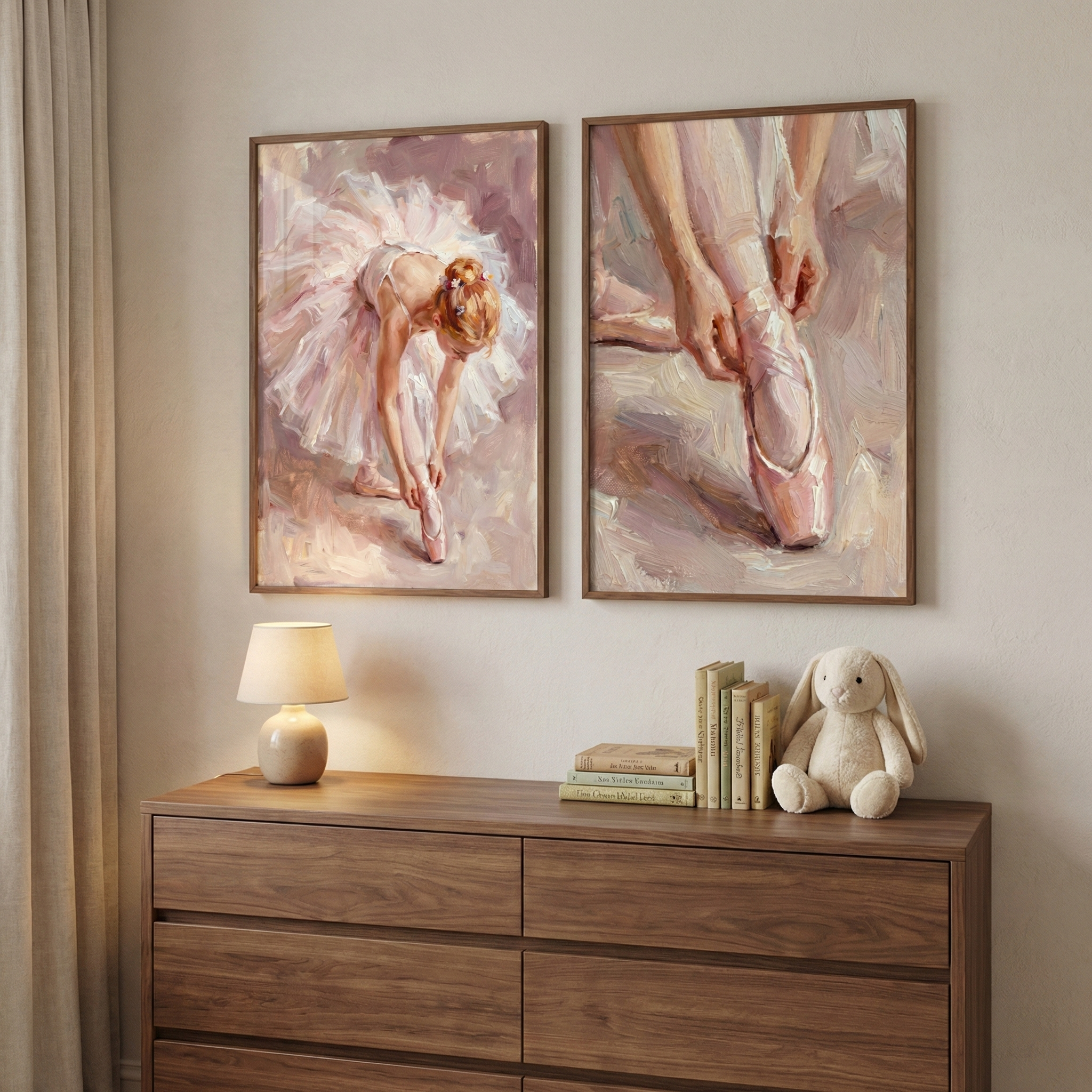 Two framed art pieces hang on a wall above a wooden dresser. The artwork on the left depicts a dancer in a white tutu adjusting her shoes, while the one on the right is a close-up of hands tying ribbons. Both display a soft, textured, impressionistic style with a palette of pinks and creams. Below, on the dresser, sits a small lamp, a few books, and a stuffed cream rabbit toy. A neutral curtain hangs to the left, adding to the room's calm and gentle aesthetic.