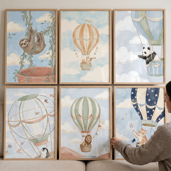 Soft blue balloon animals wall art set of 6 featuring a panda, lion, and tiger in hot air balloons among soft clouds.