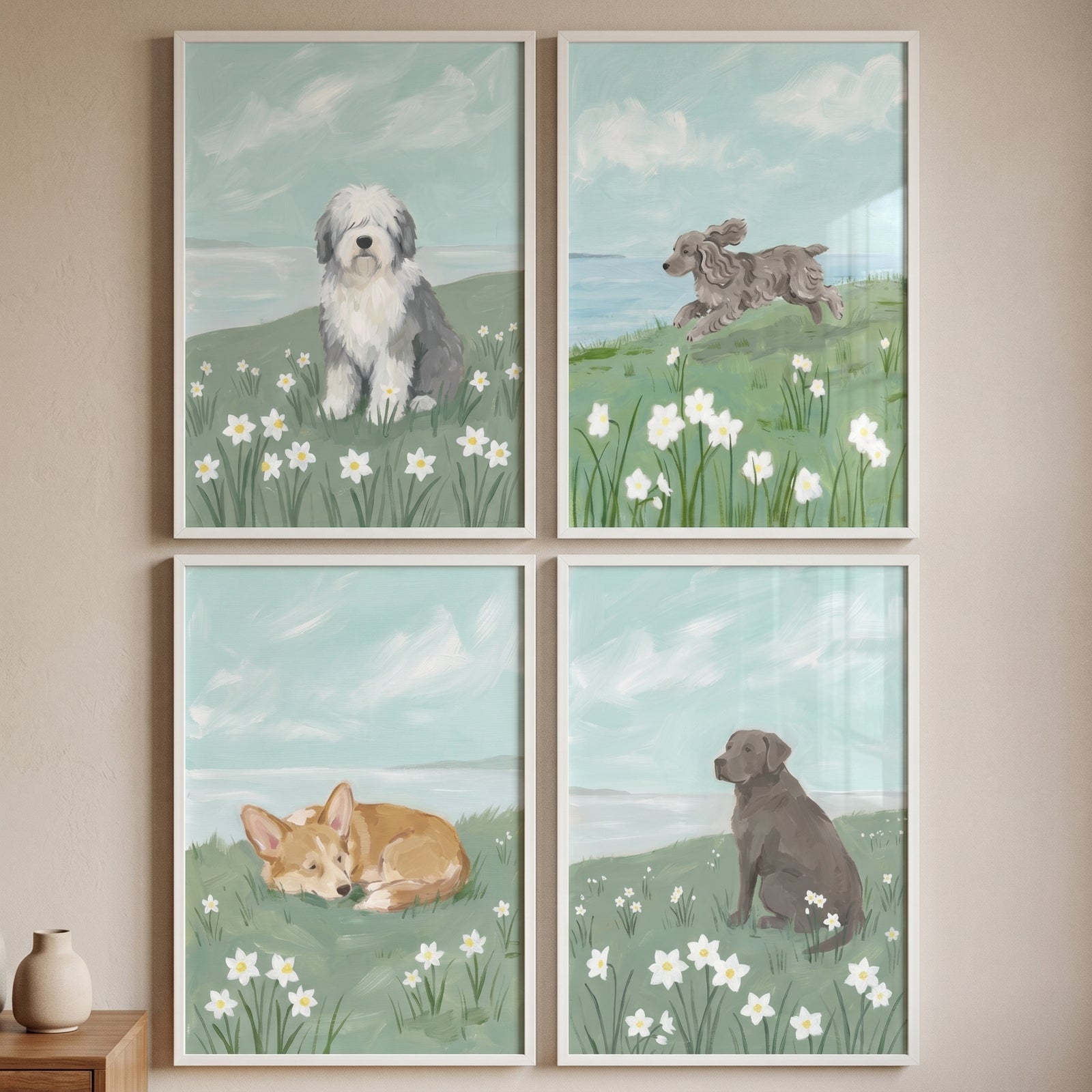 soft blue coastal dog wall art set of 4 with a sheepdog, jumping poodle, sleeping corgi, and sitting lab in meadows.