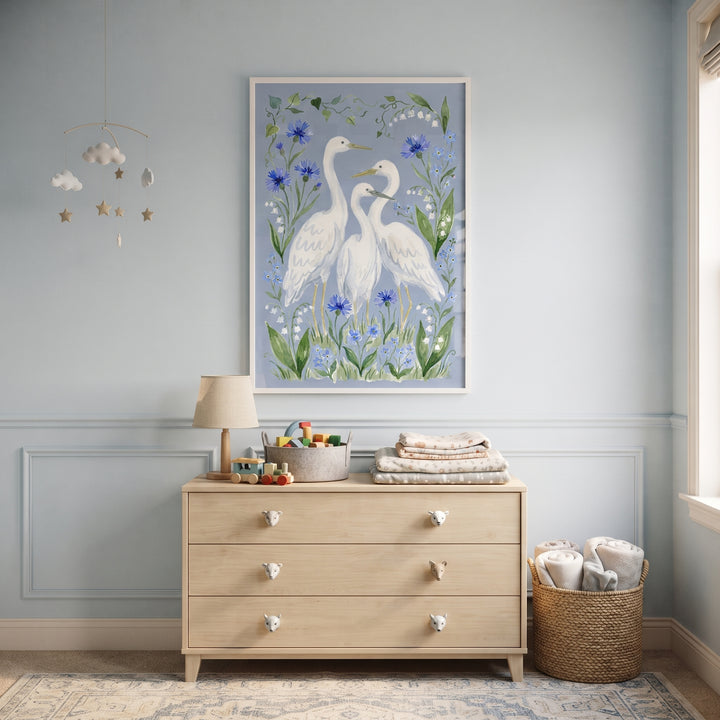 Soft blue floral egret bird wall art hangs above a wooden dresser in a serene nursery with a star mobile.