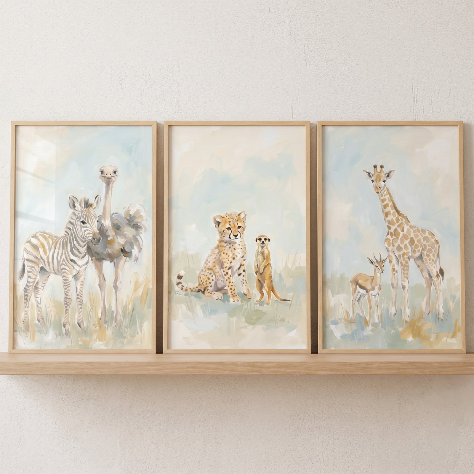 Framed zebra, ostrich, cheetah, meerkat, giraffe, and gazelle soft blue savanna animals wall art set of 3 on a shelf.