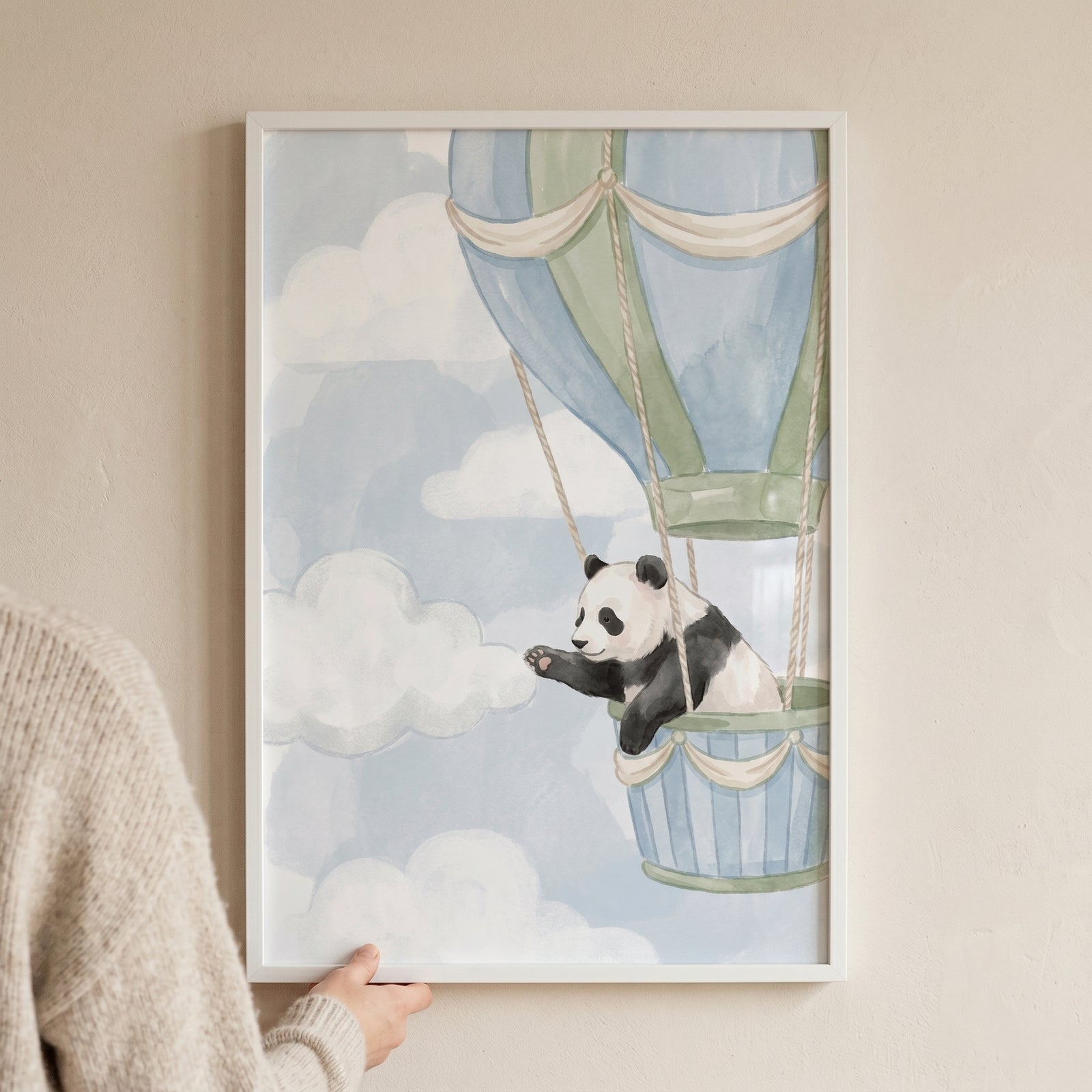 Soft blue sky panda artwork of a panda waving from a hot air balloon basket floating among fluffy white clouds.