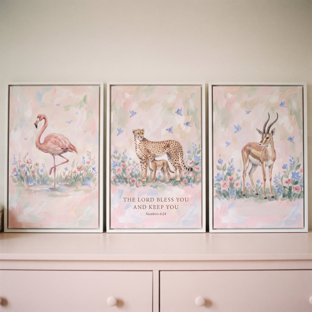Soft botanical savanna animals wall art set of 3 with a flamingo, cheetah with cub, and gazelle among pastel wildflowers.