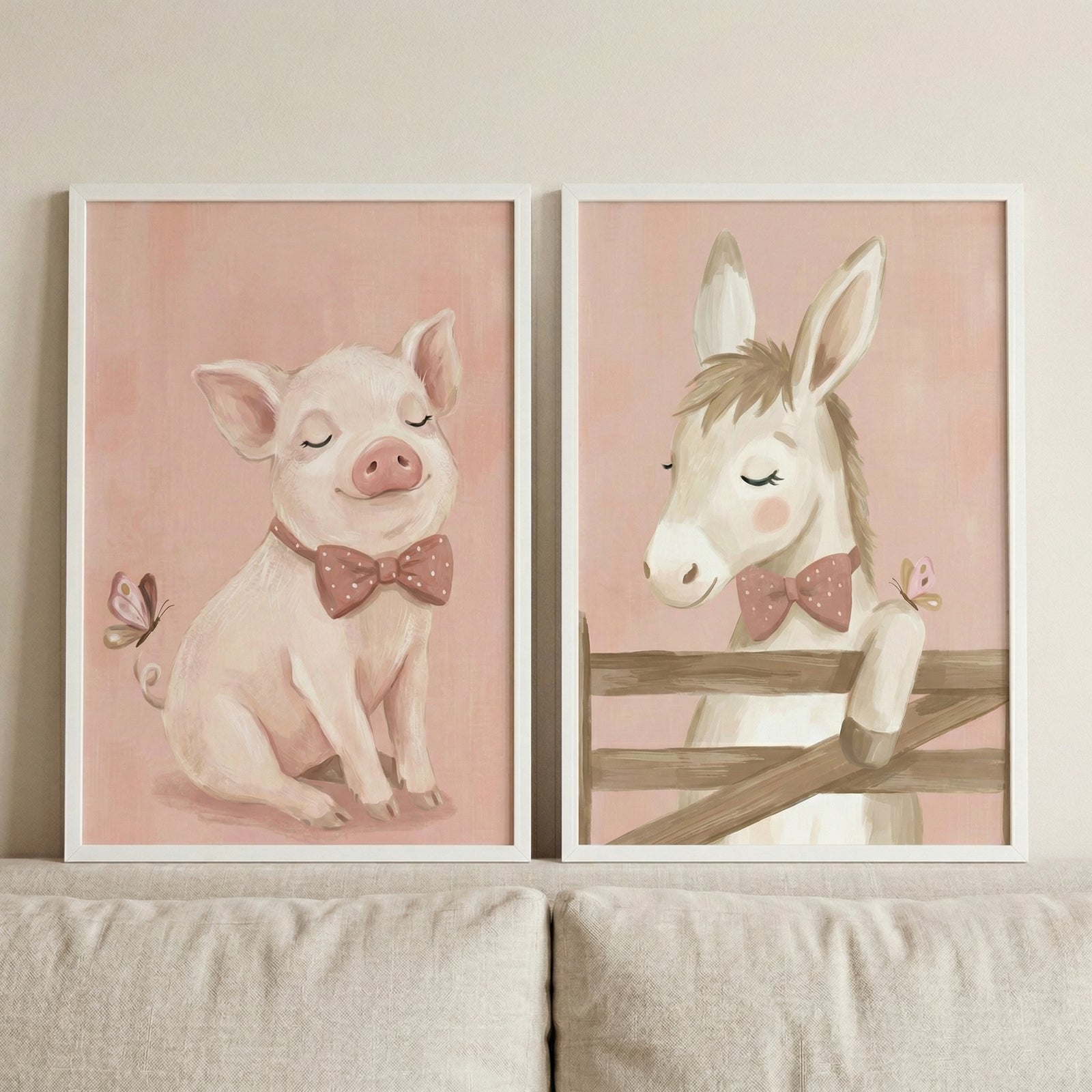 Two vertical white-framed art prints hang side-by-side on a light beige wall above a neutral-toned fabric sofa. 

The print on the left features a whimsical, soft pink pig with closed eyes and a contented expression. The pig is sitting and wearing a dark pink bow tie decorated with white polka dots. A small butterfly with pink and brown wings is shown fluttering near the pig's ear.

