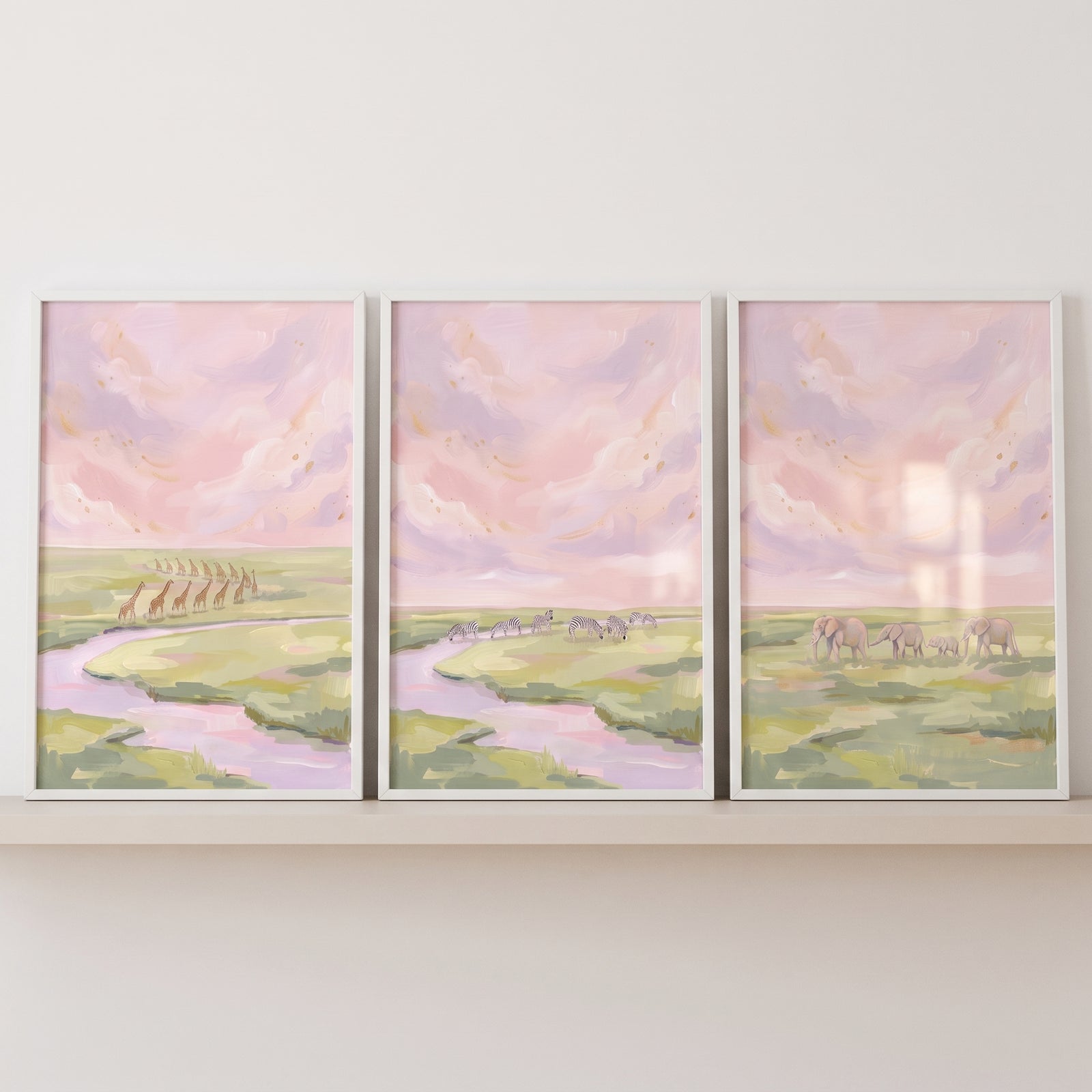 Soft cloudy safari animals wall art set of 3 features pastel giraffes, zebras, and elephants in a grassy landscape.