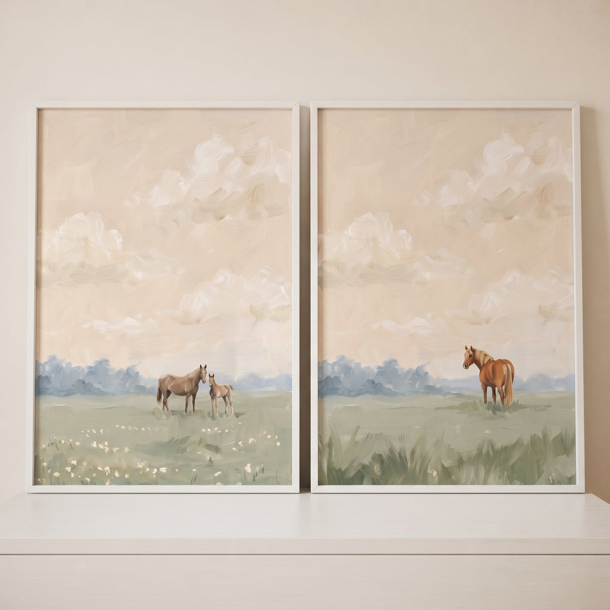 White framed soft countryside landscape horse wall art set of 2 with horses in a meadow under a cloudy beige sky.