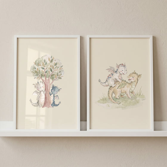 Watercolor soft fairytale baby dragons wall art set of 2 with cute dragons peeking near a tree and playing on grass.