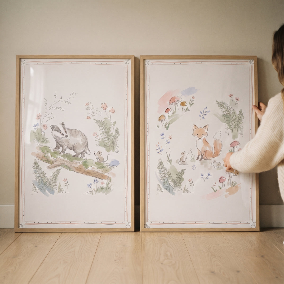 A soft garden woodland animal wall art set of 2 with watercolor illustrations of a fox and badger in light wood frames.