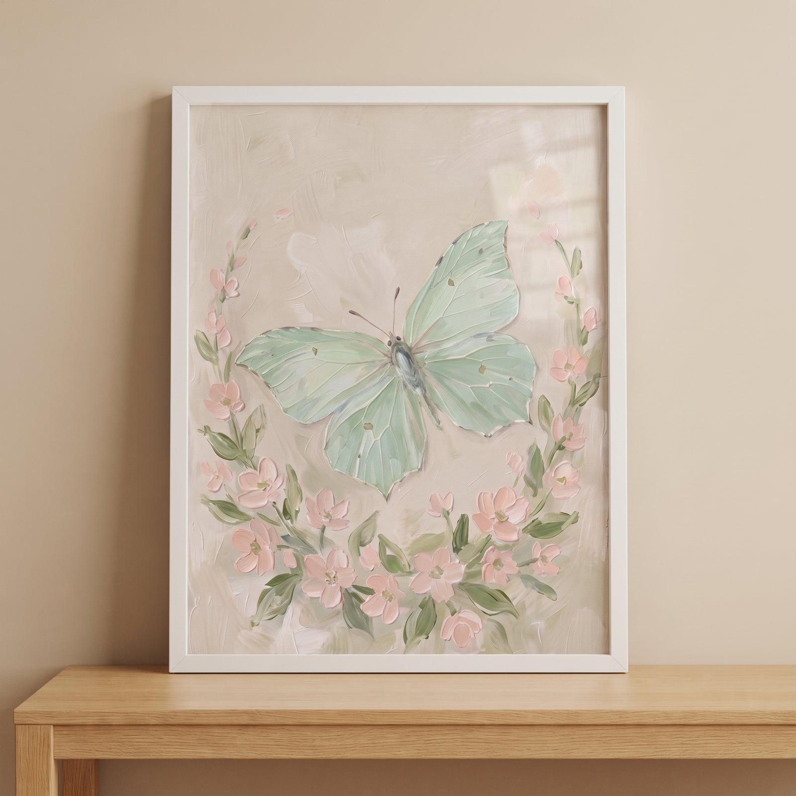 Soft mint green butterfly wall art surrounded by pink flowers in a white frame on a light wood table.
