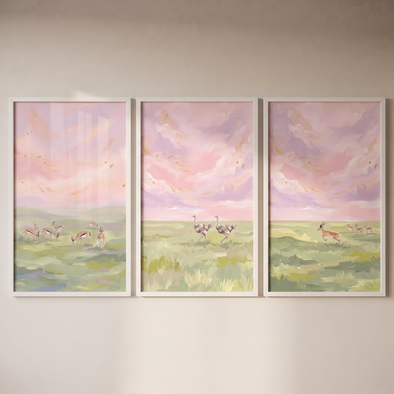Soft palette savanna animals wall art set of 3 showing gazelles and ostriches in a field under a pink and purple sky.