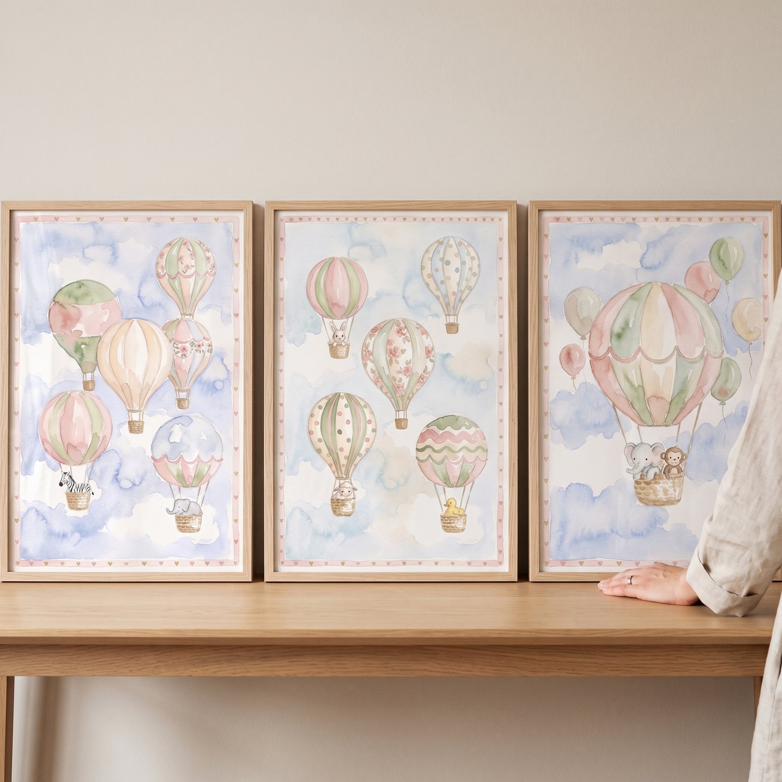 Three framed watercolor prints of animals in hot air balloons make up this soft pastel animal balloon wall art set of 3.