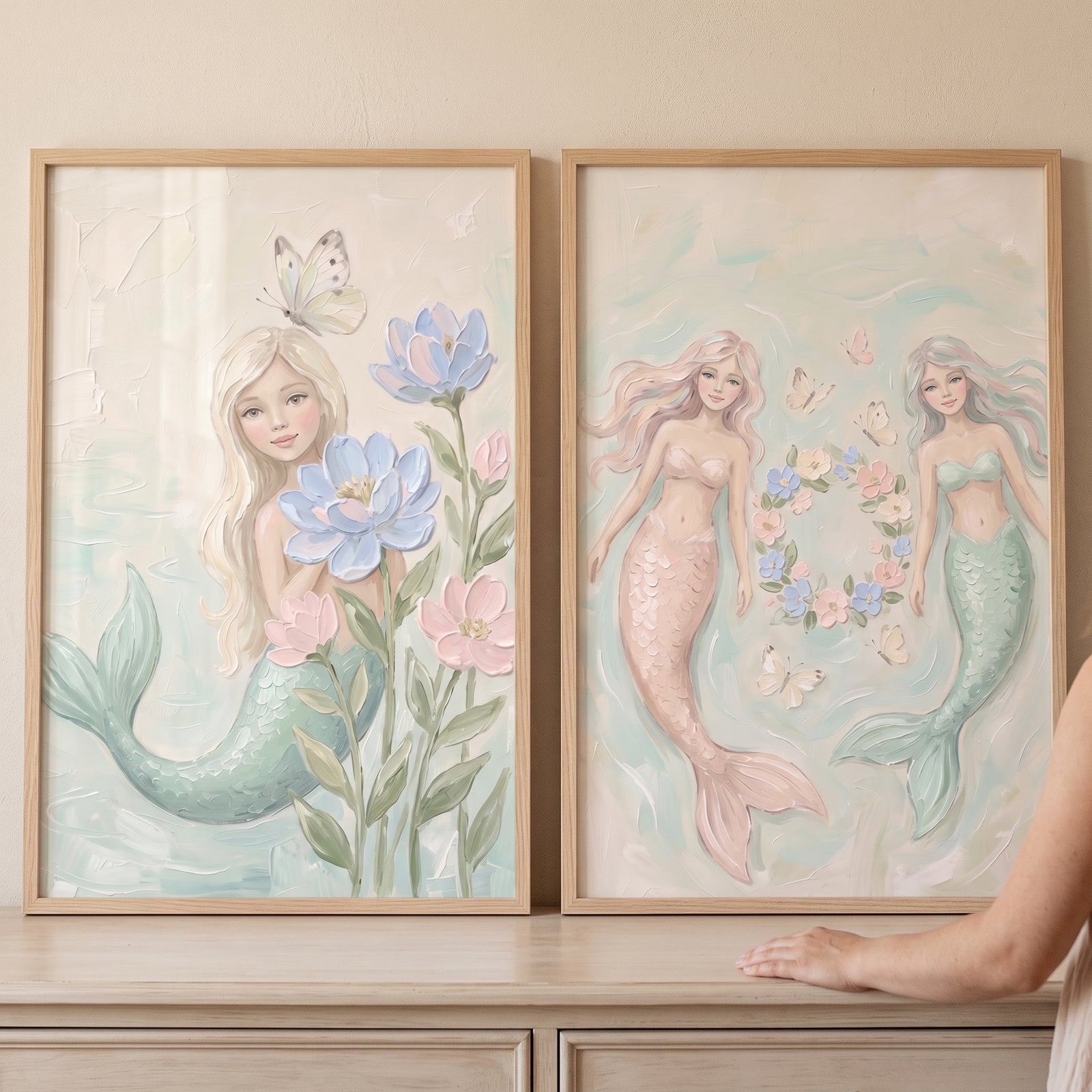 Soft pastel ethereal mermaid wall art set of 2 featuring mermaids with flowers and butterflies in light wood frames.