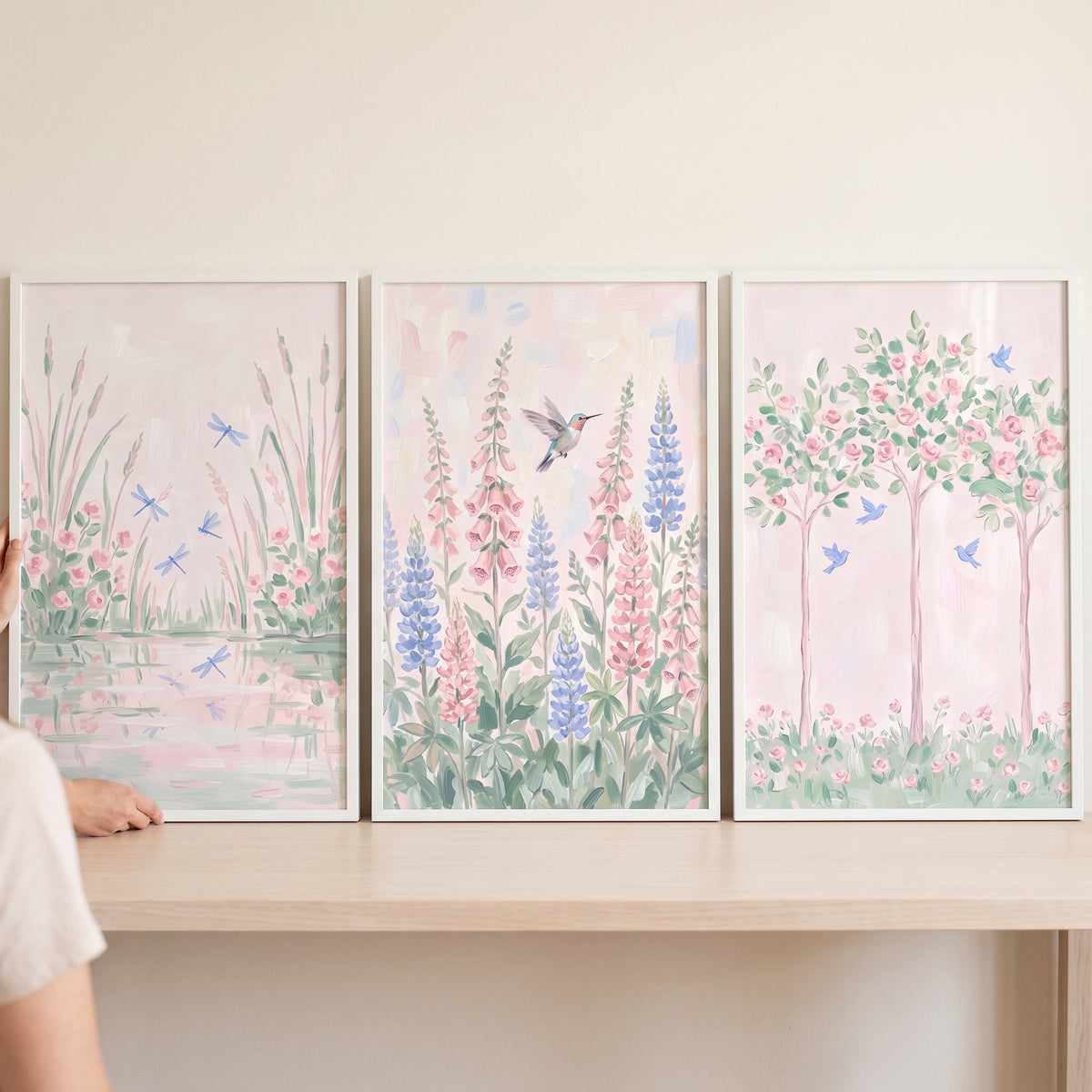 Soft pastel garden wall art set of 3 depicting dragonflies over water, a hummingbird, and birds in blooming rose trees.