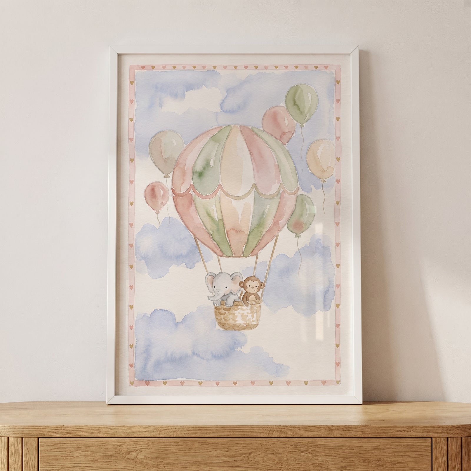 Framed soft pastel safari animal wall art of a monkey and elephant in a hot air balloon floating among clouds.