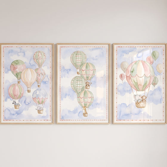 Soft pastel safari animal wall art set of 3 featuring hot air balloons with a zebra, elephant, giraffe, and monkey.