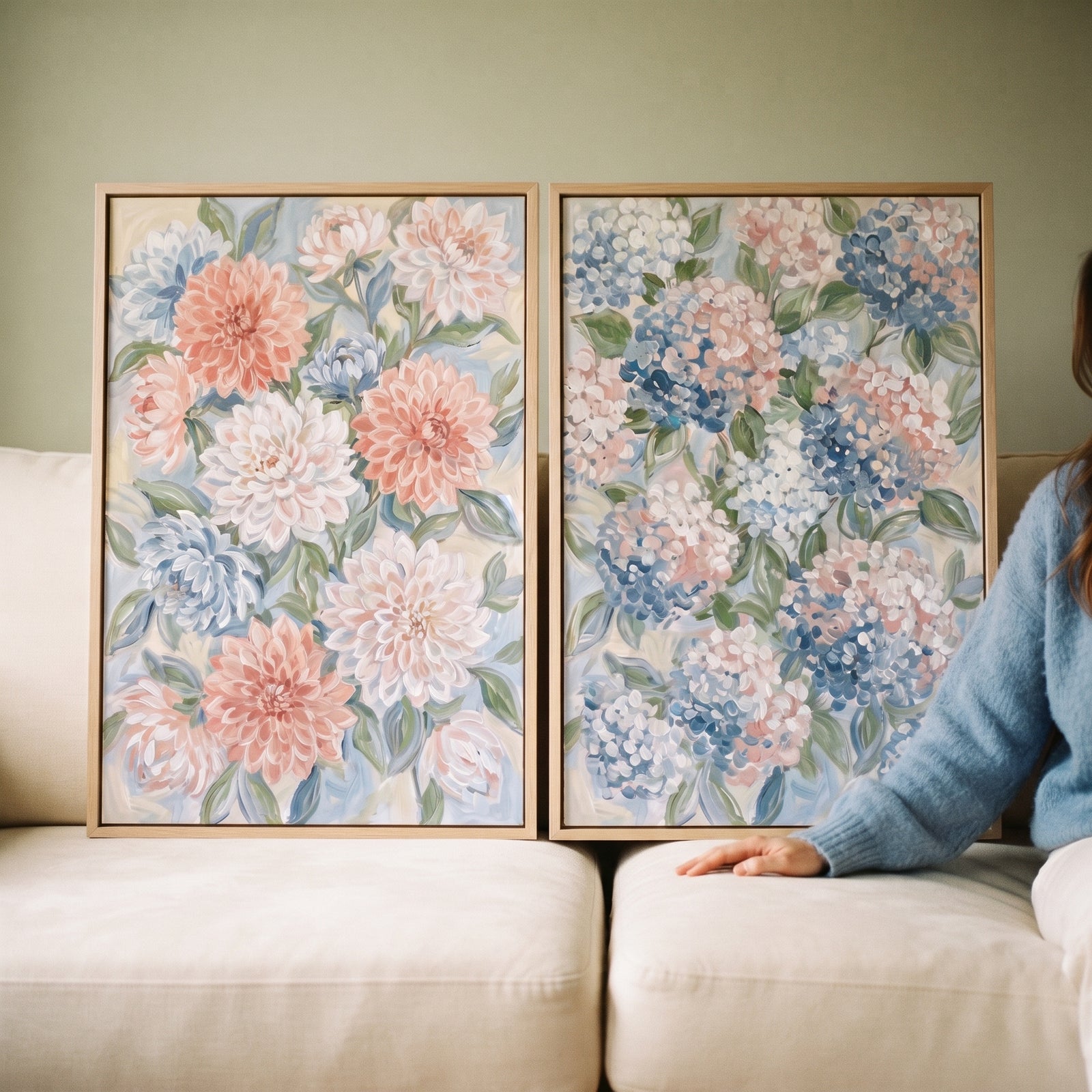 Soft pastel sage floral wall art set of 2 featuring dahlias and hydrangeas in wooden frames resting on a sofa.