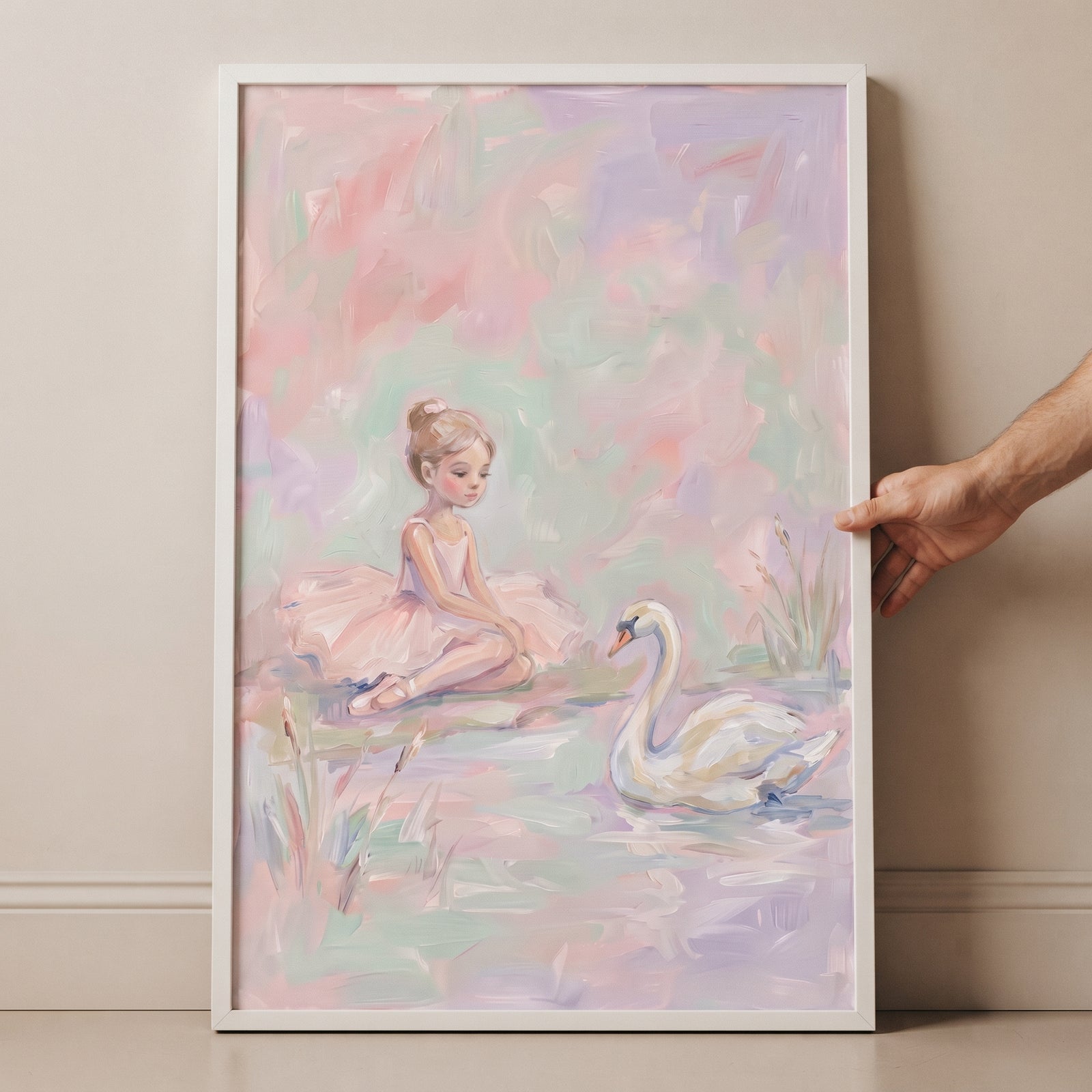 Framed soft pastel sitting ballerina wall art of a young girl in a pink tutu watching a white swan on a pond.