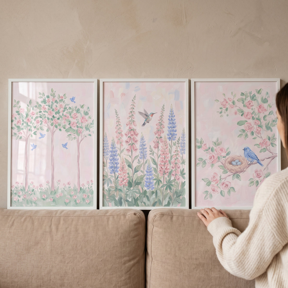 Soft pastel spring garden wall art set of 3 featuring birds and flowers displayed on a wall behind a beige sofa.
