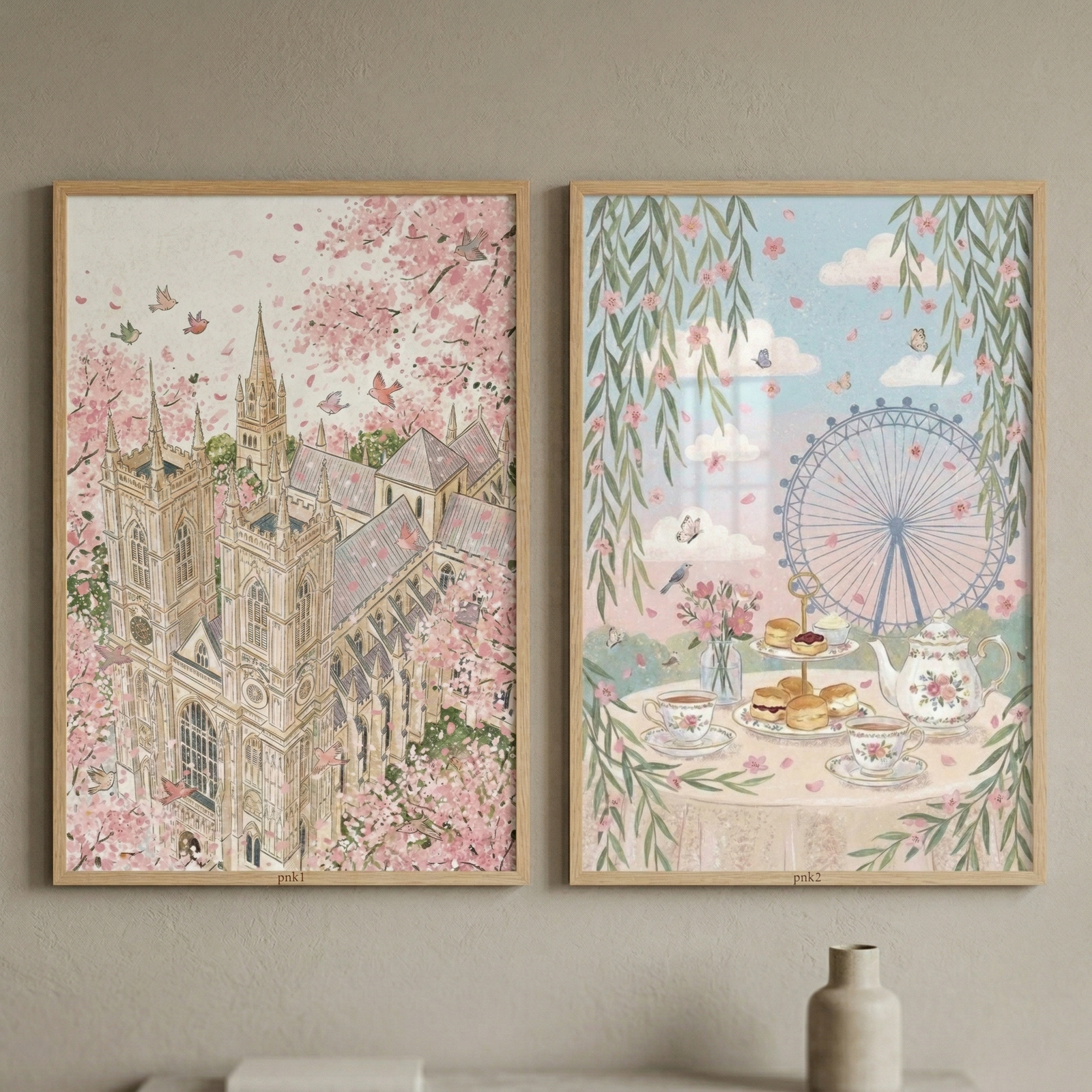 Two vertical framed illustrations hang side-by-side on a neutral-colored wall. Both pieces are encased in light-toned wood frames and share a delicate, whimsical aesthetic with soft pastel colors.

The artwork on the left depicts a grand Gothic cathedral with intricate architectural details, including tall spires and arched windows. The historic building is nestled among a dense canopy of pale pink blossoms. 