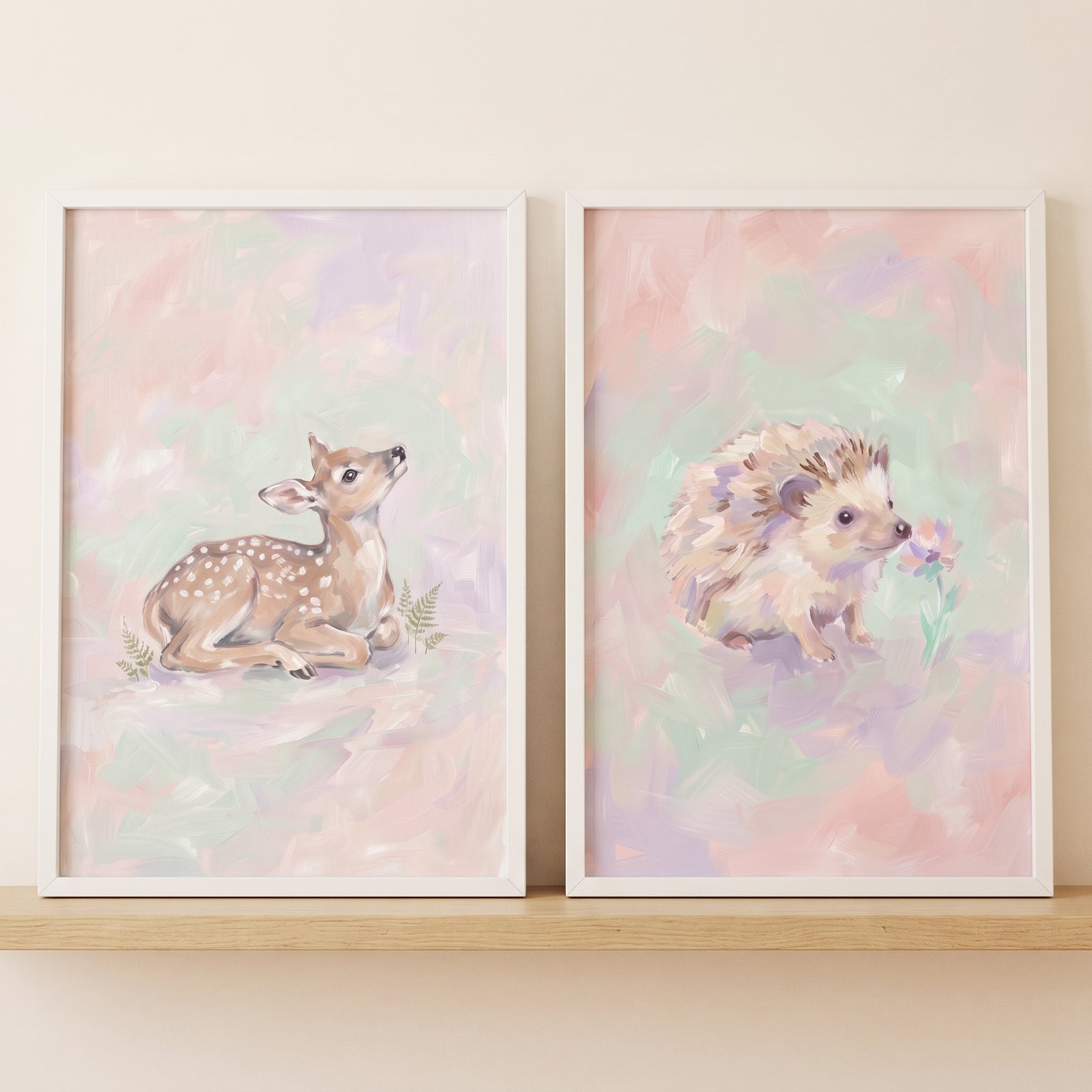 Soft pastel woodland animal wall art set of 2 featuring a deer and a hedgehog displayed on a light wooden shelf.