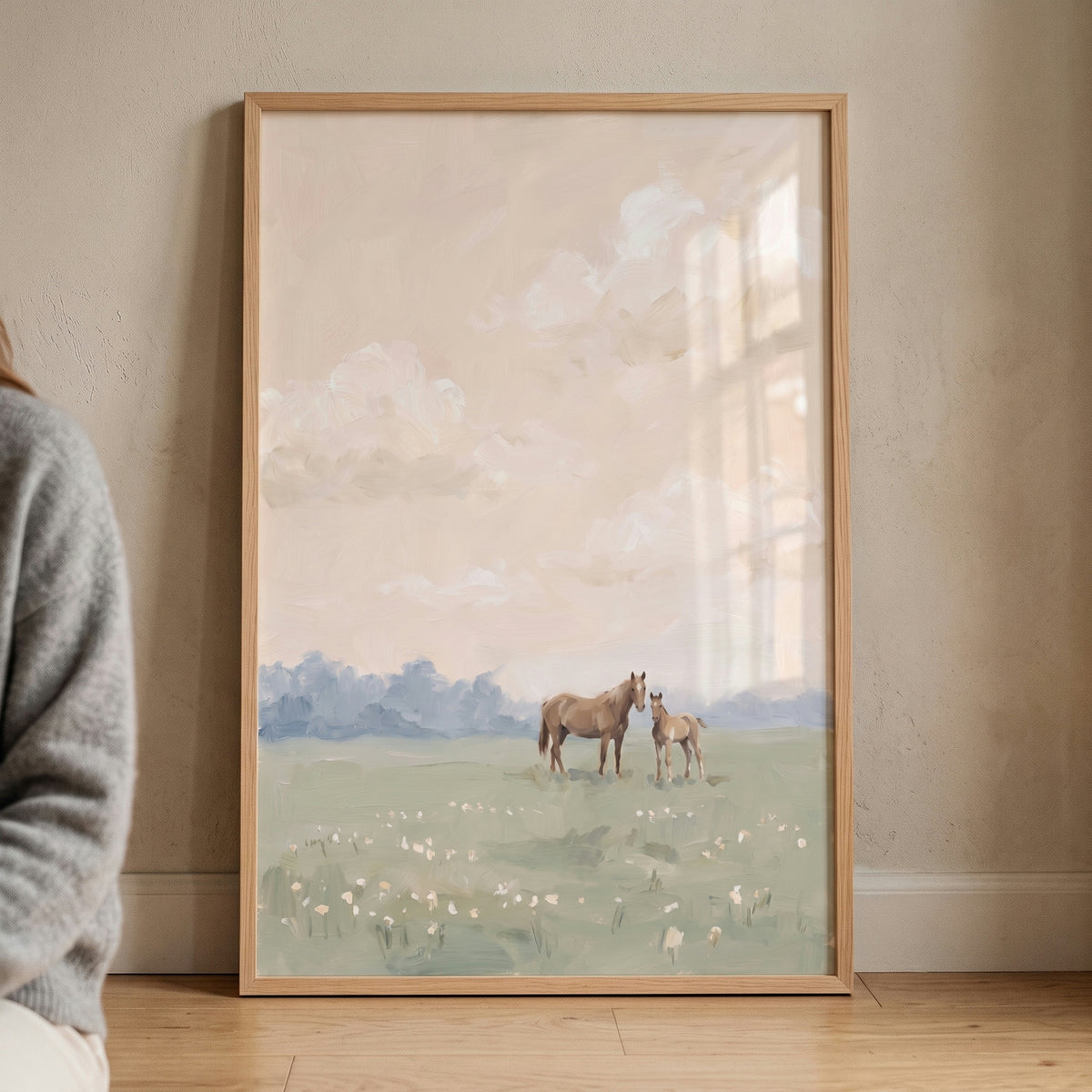 Framed soft peach meadow horse wall art depicting a brown mare and foal in a flower field under a cloudy sky.