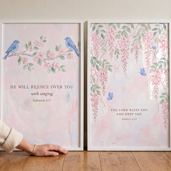 Soft pink botanical scripture artwork set of 2 featuring blue birds, pink flowers, and Bible verses in white frames.