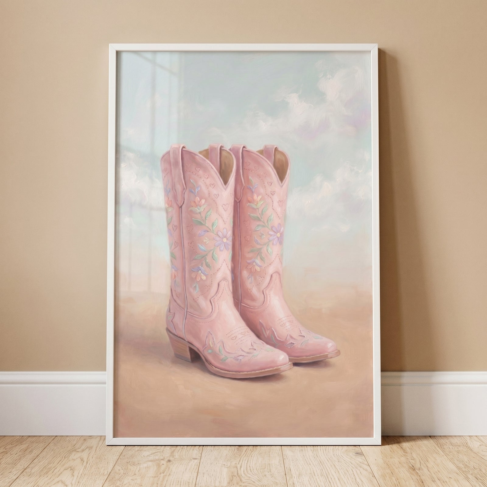 Framed soft pink floral boots wall art featuring embroidered western footwear against a cloudy sky and sandy ground.